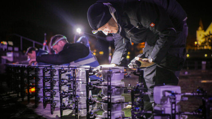 Techniker der deutschen Firma DroneDreams präparieren die LED-Drohnen für eine S ...